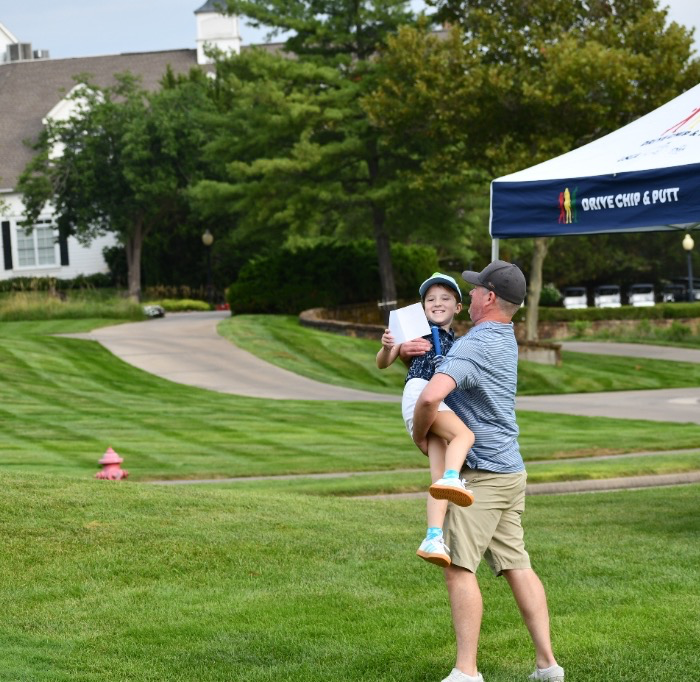 Father celebrating with his son at a Drive, Chip & Putt qualifying event